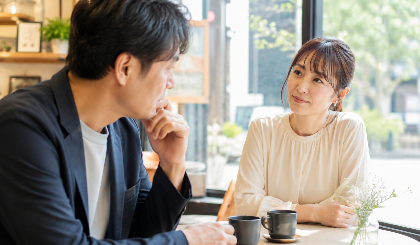 40代で初婚の男性が女性とカフェで向き合い相手からどう見られるかを気にしている写真